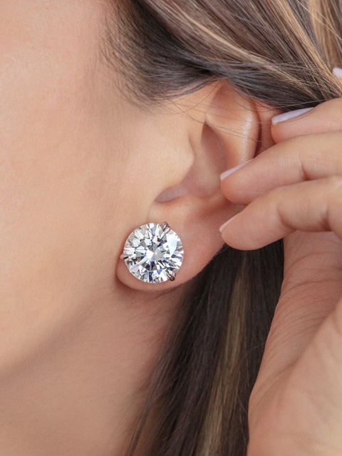 A close-up of a woman’s ear, adorned with a single dazzling diamond stud earring. A close-up of a woman’s ear, adorned with a single dazzling diamond stud earring.