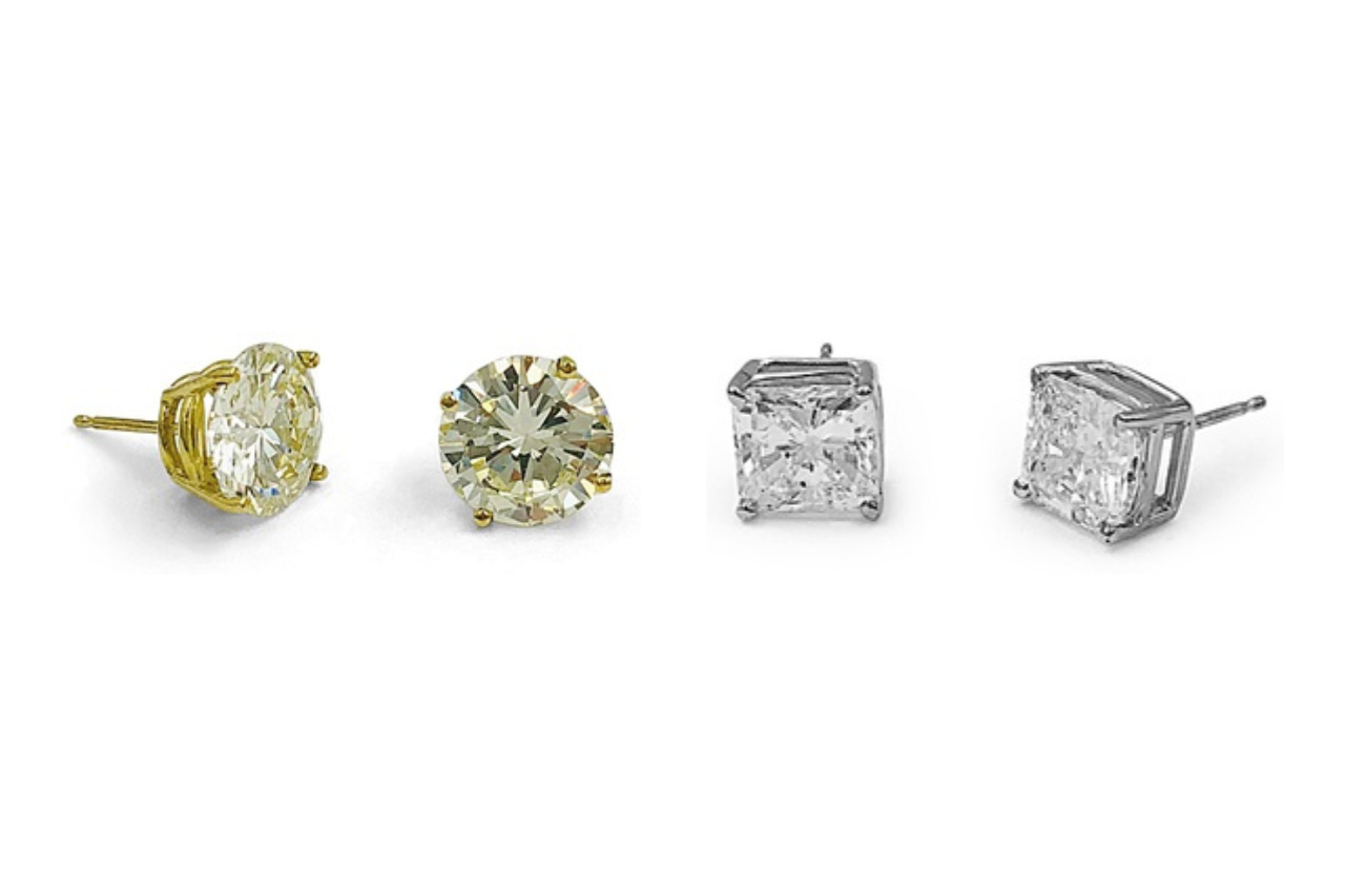 Two pairs of diamond stud earrings, one with round cut diamonds set in yellow gold and the other with princess cut diamonds set in white gold, both available at Alson Jewelers. Two pairs of diamond stud earrings, one with round cut diamonds set in yellow gold and the other with princess cut diamonds set in white gold, both available at Alson Jewelers.