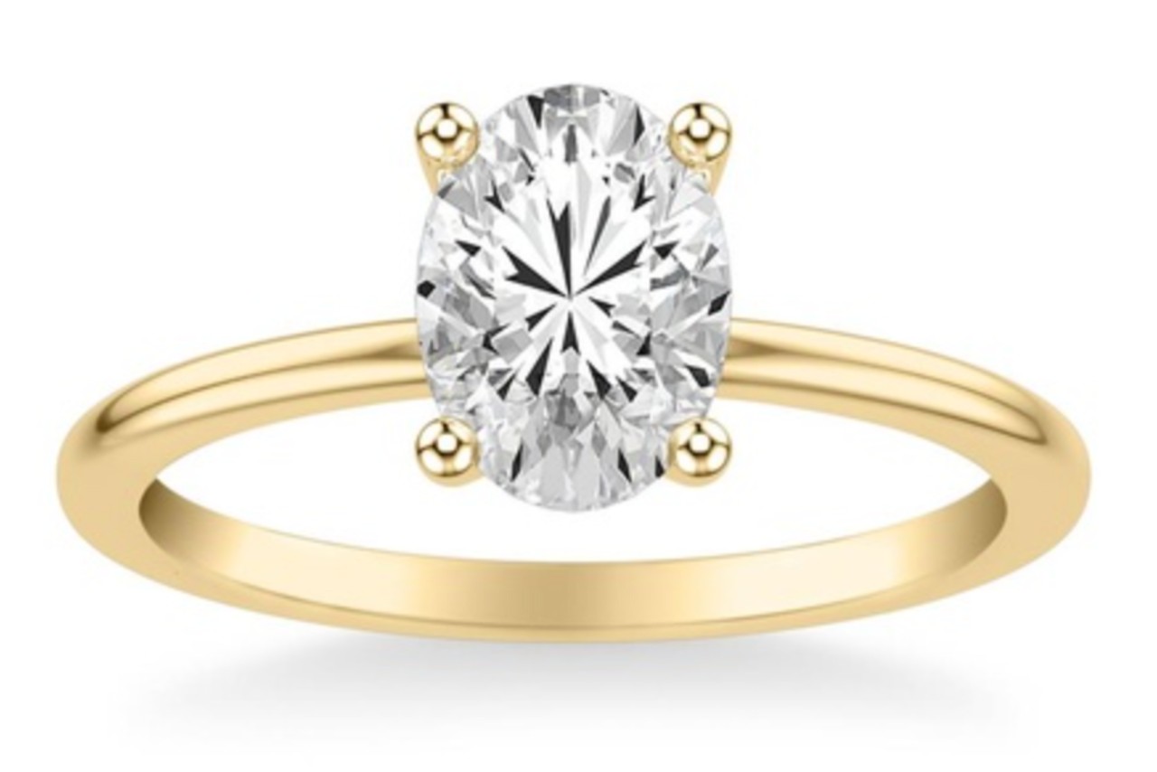 a yellow gold solitaire engagement ring with an oval cut diamond a yellow gold solitaire engagement ring with an oval cut diamond