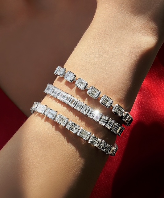 A close-up of a woman’s wrist adorned in three stunning diamond tennis bracelets. A close-up of a woman’s wrist adorned in three stunning diamond tennis bracelets.